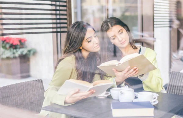 Girls reading book in a bar — Stock Photo, Image