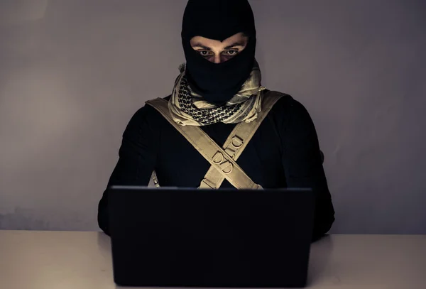Terrorysta pracuje na swoim komputerze. — Zdjęcie stockowe