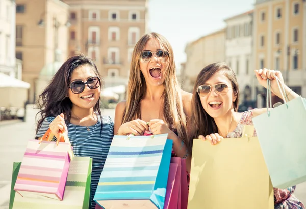 Три счастливые девушки веселятся и делают покупки — стоковое фото