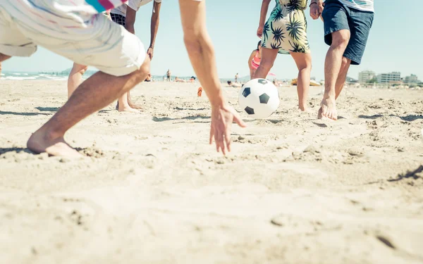 Gruppo di amici che si divertono sulla spiaggia giocando a calcio — Foto Stock