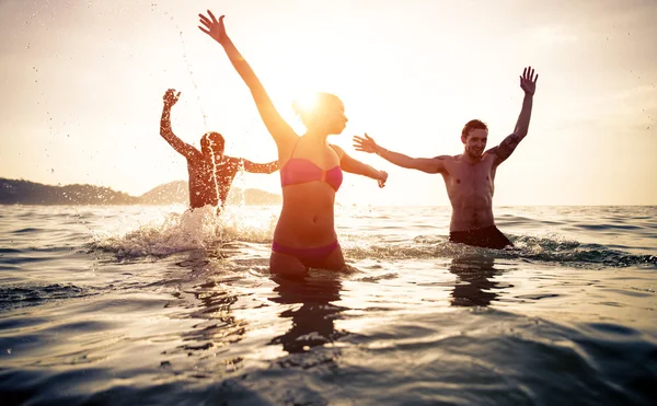 Grupo de amigos saltando y haciendo fiesta en el agua —  Fotos de Stock