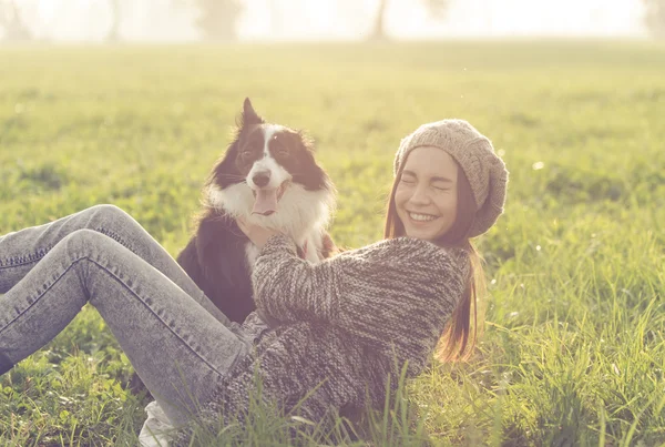 Jovem mulher brincando com sua fronteira collie cão — Fotografia de Stock