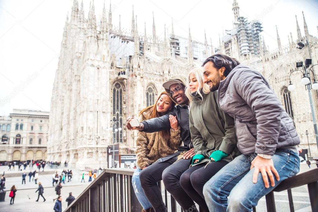 Multiracial group of friends taking selfie in Milan