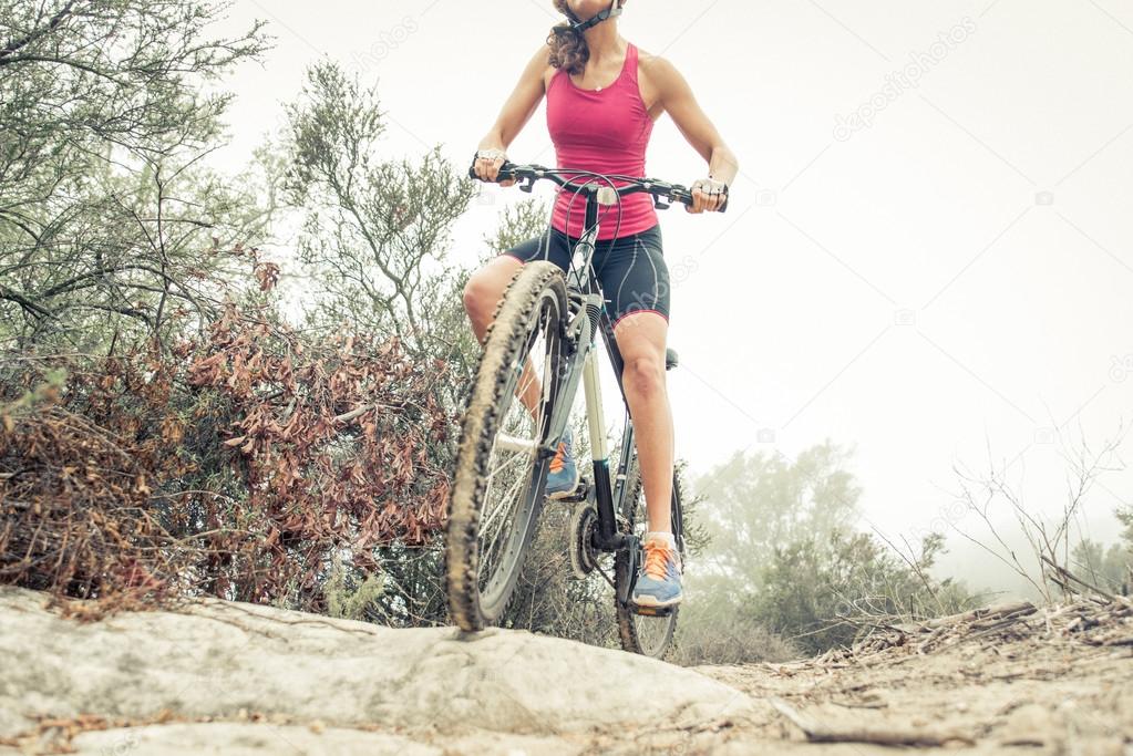 Woman making downhill with mountain bike. Concept about people