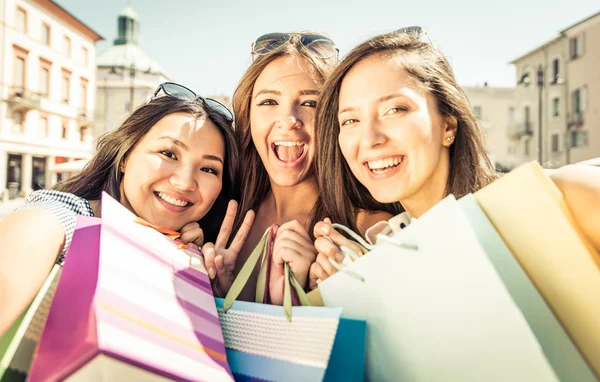 Drie gelukkige meisjes met plezier en waardoor winkelen — Stockfoto