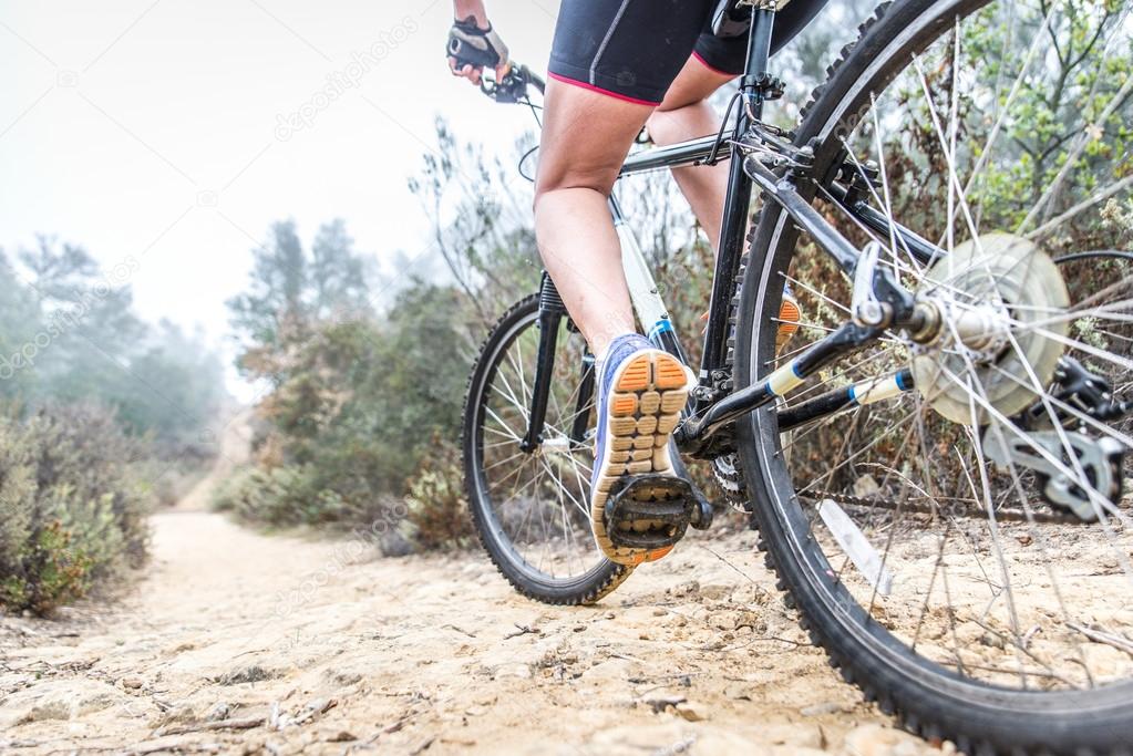 Woman making downhill with mountain bike. Concept about people a