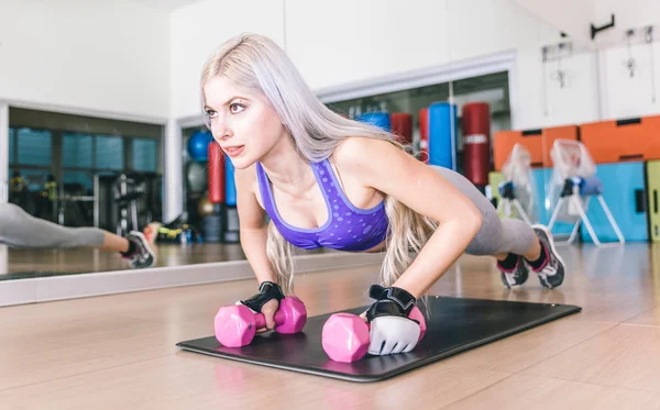 Menina bonita fazendo flexões em halteres — Fotografia de Stock