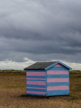 Suffolk sahilindeki çok renkli plaj kulübelerinde.