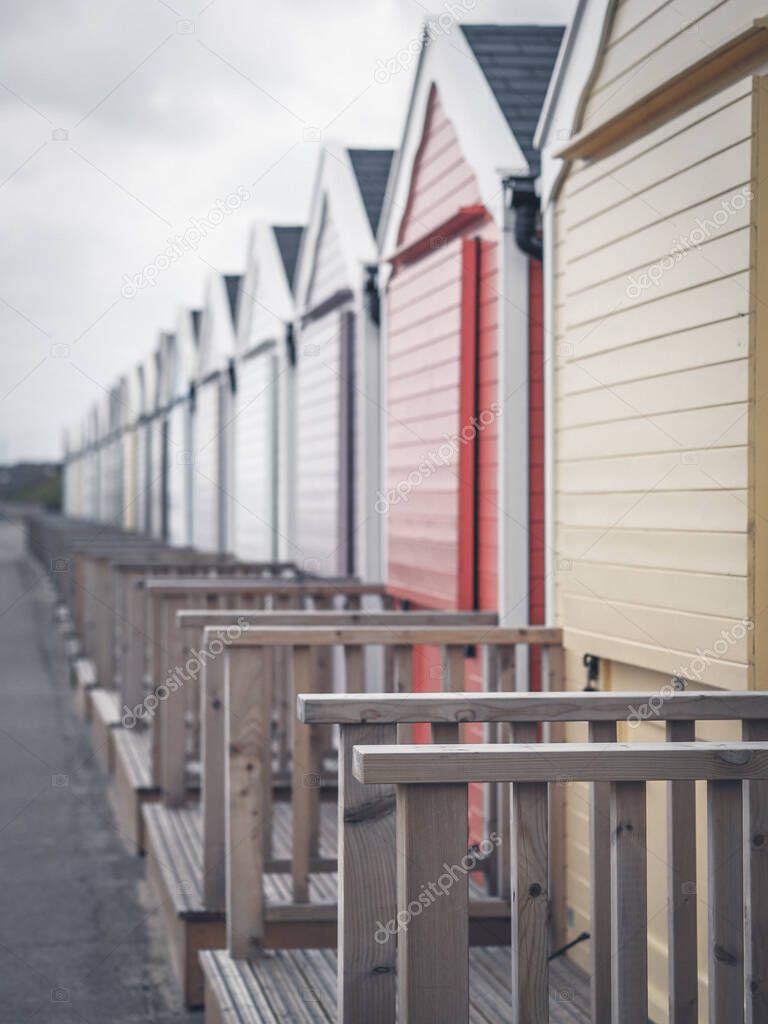 row of multicoloured beach huts on Suffolk coast
