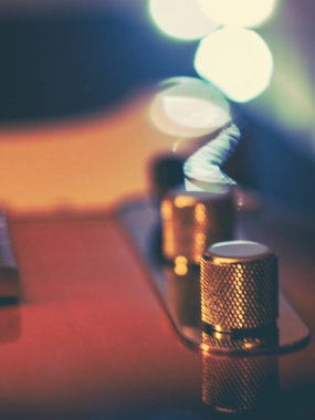 Elektro gitar, bokeh efekti ışıkları ve ahşap arkaplan ile kapanıyor