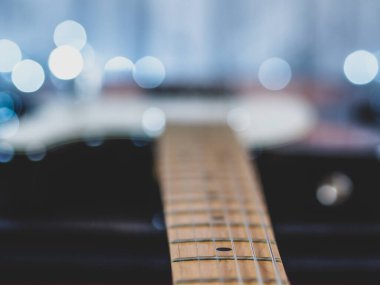 Elektro gitar, bokeh efekti ışıkları ve ahşap arkaplan ile kapanıyor
