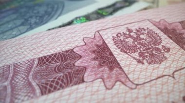 Kırmızı kapaklı Rusya Federasyonu 'nun yabancı pasaportları. Pasaporttaki ulusal amblem makro çekimde. Ülkenin sembolü çekiç ve orakla çift başlı kartaldır.