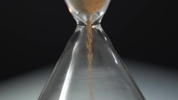 Hour glass in macro shot. Camera move down. Yellow sand Falling Move Through Hour Glass. Crystal Diamond. Sand Running Through Bulbs of an Hourglass Measuring Passing Time Countdown to Deadline, on — Stock Video