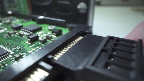 コンピュータを修理しろ。修復電源ケーブルをハードドライブディスクに接続します。HDD固定概念。マクロショット。シリコンチップを閉じるショット. — ストック動画