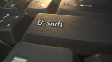 İş adamı gün batımında birkaç kez karanlık klavyede vardiya tuşuna bastı. Makro atış. Tablet bilgisayarı üzerinde çalışırken, Klavye 4K 'de insan eli çok yakın.