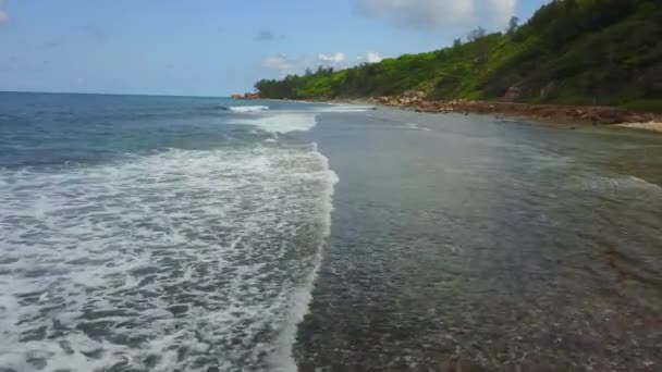 Costa delle Seychelles. Grandi onde si infrangono sulla costa. Rocce sulla riva. Un paradiso. Direzione popolare per le persone ricche e di successo. Cielo blu. Oceano Indiano con bella laguna. Colpo aereo da — Video Stock