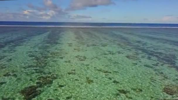 Křišťálově modrá laguna v karibském moři. Bahamské ostrovy. Vlny se valí nad lagunou. Mělké vody a mnoho útesů. Modrá obloha s kulkami. Ráj. Letecký záběr z dronu — Stock video