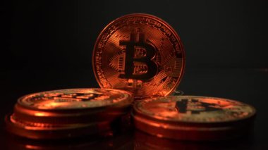 Bitcoin paraları izole edilmiş siyah yüzeyde. Altın ışık yansıtır. Dünya kripto para birimi. İş ve finans kavramı. Madencilik parası. Engelleme teknolojisi. Dijital para