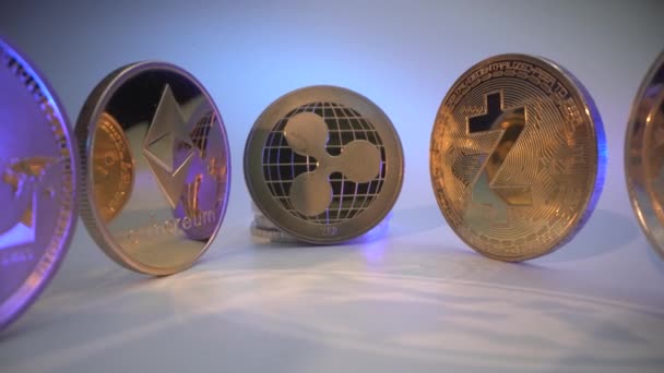 Veel gouden crypto munten op het witte oppervlak met reflectie op de tafel. Bitcoin, Etherium, Rimpel, litecoïne. Blockchain technologie. Neon licht op de munt. Online Trading concept. Beurzen — Stockvideo