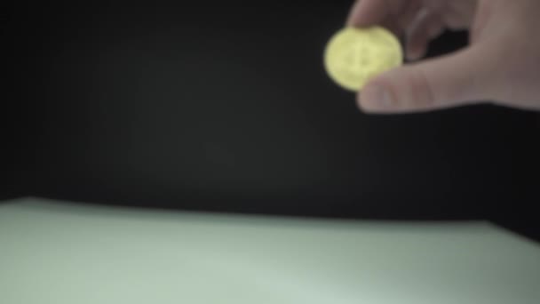 Der Mensch hält Gold-Bitcoin in der Hand. Makroschuss. Schwarzer Hintergrund. Kryptowährungskonzept. Blockchain-Technologie der Zukunft. — Stockvideo