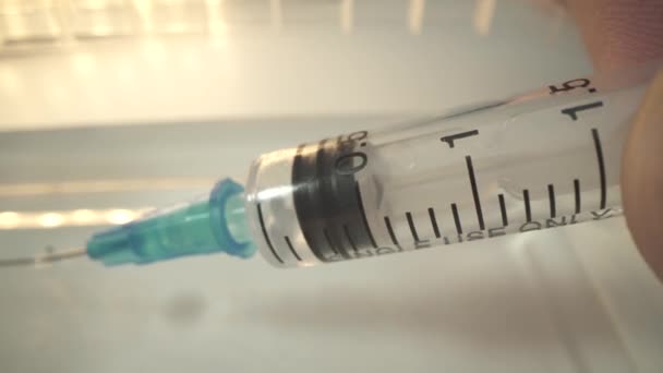 Doctors hand holds a syringe and a vaccine bottle at the hospital. Health and medical concepts. Covid epidemic. macro shot. — Stock Video