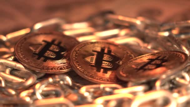 3 bitcoins de ouro giram sobre a mesa com corrente como tecnologia blockchain. Conceito financeiro. Situação de Bitcoin no mundo. Bitcoin Ouro, BTC, Moeda Bit. Macro shot. Conceito de Negócio e Investimento — Vídeo de Stock