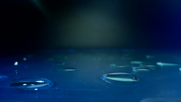 Έννοια νερού. στην επιφάνεια του γυαλιού με μπλε μήκος και πολλές σταγόνες στο τραπέζι.Το νερό είναι ένα διαφανές και σχεδόν άχρωμο χημικό που είναι το κύριο συστατικό των ρευμάτων, λίμνες και τους ωκεανούς της — Αρχείο Βίντεο