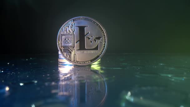 Criptografia moeda Litecoin na mesa de vidro com muitas gotas de água sobre ele. Fechar foto panorâmica. Tecnologia Blockchain de criptomoeda digital moderna. Bela luz amarela na moeda de ouro. — Vídeo de Stock