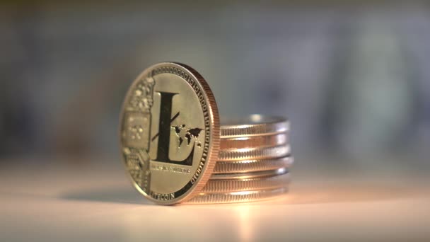 Altcoin Zlatá mince Litecoin se otáčí na povrchu s krásným odrazem. Mnoho dalších populárních kryptocoinů je také na stole. Americká bankovka na pozadí. Makro. Kryptoměna — Stock video