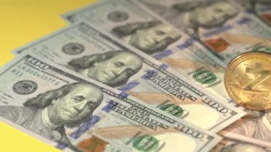 Zcash ve USD dolar. Popüler altın kripto para birimi ve sarı yüzeyde Amerikan banknotları. Masada bir sürü fatura var. Yakın plan çekim. Yeni modern teknolojiyi engelleyin. Dijital para ve nakit