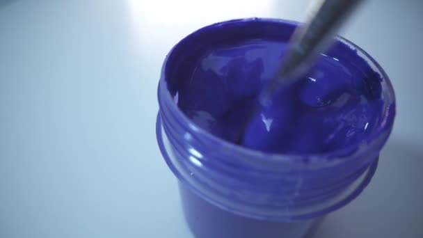 Mężczyzna trzyma pędzel w ręku gotowy do malowania niebieską farbą. Białe tło. Narysuj koncepcję obrazu. ujęcie makro. — Wideo stockowe