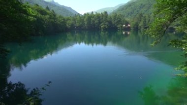 İnanılmaz alp gölü manzarası kristal berrak yeşil su ve mükemmel mavi gökyüzü. Alplerde gölü olan güzel bir dağ manzarasının panoramik görüntüsü. Kristal berrak dağ gölü suyunun üzerinde