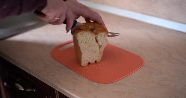 Vista de cerca de la chef hembra rebanando pan en la tabla de cortar de madera. Cortar un pan. — Vídeos de Stock