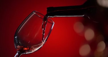 Kırmızı arka plandaki bir şişeden kırmızı şarap bardağa dökülür. Süper Yavaş Hareket Ayrıntılı Şişe Kırmızı Şarabı Şişe Kırmızı Gradyan Arkaplanı