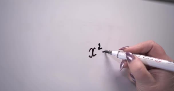 Vrouwenhand schrijft een wiskundige formule op een schoolbord. Zoek naar een oplossing. Wiskunde. school. 4k video — Stockvideo