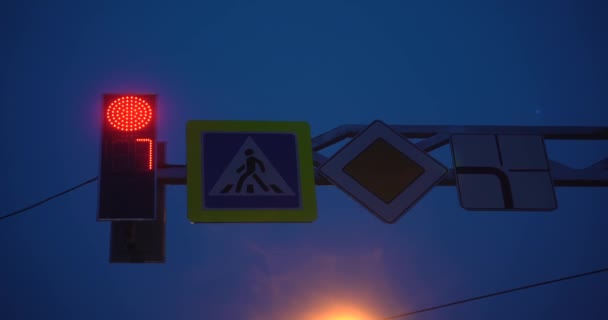 Señal de tráfico en la noche: parada y salida. Luces rojas y verdes en una señal. Vídeo 4K. Semáforos y señales de tráfico. Gran ciudad — Vídeo de stock