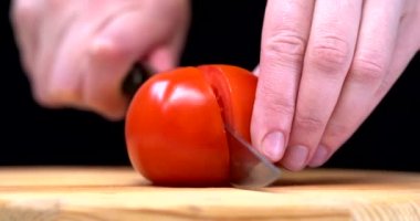 Bir kadın, salata için domatesleri bıçakla keser. Bıçak salata için sebze keser. Domates, salatalık, avokado ve marul. 4k video