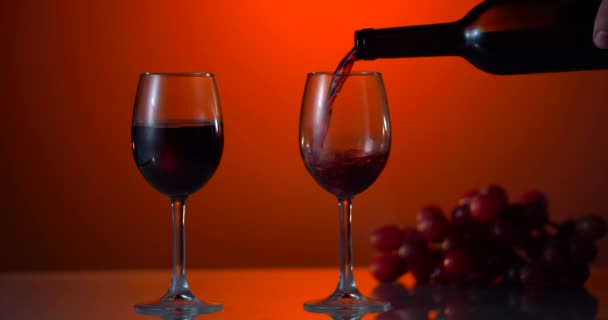 Красное вино образует красивую волну. Вино наливается в бокал вина на белом фоне. Крупный план. Медленное движение наливания красного вина из бутылки в бокал. Супер-медленное движение — стоковое видео