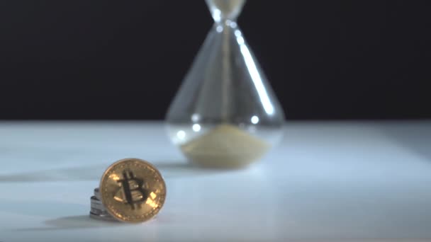 Bitcoin BTC met zandloper ligt op tafel. Tijd is geld concept. Mijnbouw en handel. Cryptogeld. Gouden hoofdmunt — Stockvideo