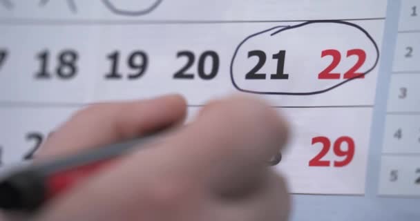 A mão circunda os dias de fim de semana no calendário. a mão coloca um lembrete no calendário sobre a reunião. reunião. um evento importante. cartão de recordação. Fechar em um calendário com DAY OFF sendo — Vídeo de Stock