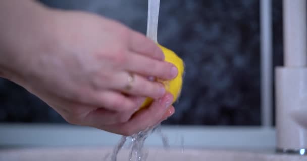 Citroenen wassen, water uit de kraan halen, citroenen ontsmetten, fruit ontsmetten, selectieve focus, waterkraan. 4k video — Stockvideo
