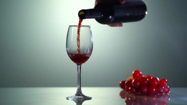 Şişeden bardağa kırmızı şarap döküyorum. Sicilya 'daki üzüm bağlarında. Sommelier, arka planda Etna volkanı olan kırmızı şarabı bardağa dolduruyor. Şarap kadehini kırmızı şarapla doldur.