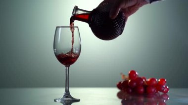 Mans bir sürahide kırmızı şarap doldurur. Bardakta kırmızı şarap, yakın plan. Eski grunge vintage tarzı.