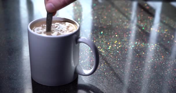 Close-up of coffee with milk. coffee cup stirred with spoon. Sun light on the table. Person hand move drink teaspoon. Close-up fingers stirring glass espresso macchiato. Sunny day — Stock Video