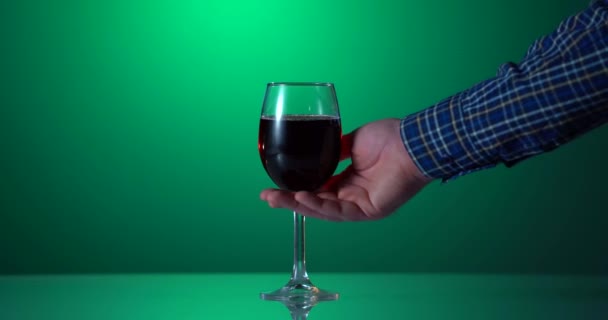 Рука крупним планом бере червоний келих вина. 4k відео руки з червоним вином в кришталево чистому келиху вина. Винний бар або винзавод . — стокове відео