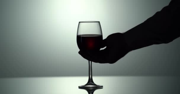 Mans el kırmızı şarap alır güzel bir dalga oluşturur. Düşük tuşlu 4k video — Stok video