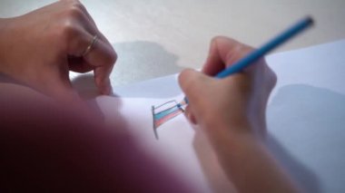 Beyaz kağıda mavi kalemle çizen genç bir kız. Rus bayrağı. Country konsepti. Ulus. Kapat.