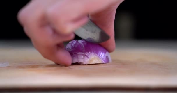 한 여인의 손 이 칼로 붉은 양파를 썰어 내는 모습을 가까이 서 볼 수있다. 빨간 양파 고리. 음식을 준비 한다. 양파자르기. 요리하는 과정. — 비디오