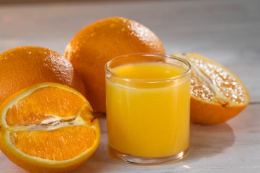 Portakal suyu, portakalın yarısı ahşap beyaz masada. Yaz havası. Yakın çekim. ham görüntüler