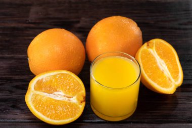 Portakal suyu, portakalın yarısı ahşap masada. Yaz havası. Yakın çekim.